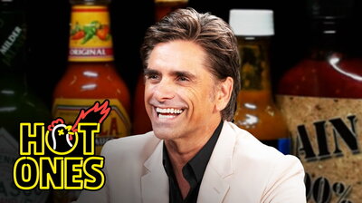 John Stamos Falls Out of His Chair While Eating Spicy Wings